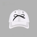 Close-up of a white cotton baseball cap featuring detailed black bow-tie embroidery - Denim Bow Baseball Cap Style / White