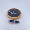 Dettaglio macro della spilla a farfalla con zirconi blu e bianchi su supporto in velluto - Farfalla Multicolore Blu Bianco e Rosso