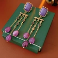 Detalle de pendientes vintage dorados con piedras púrpuras y perlas de gota de agua - Dorado/Púrpura