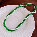 Detail of double-layer necklace with green beads and pearls on a white ceramic plate - Green Glass Pearl Double Layer Necklace