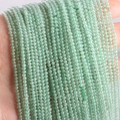 Strands of 2mm green aventurine natural stone round beads held in hand for jewelry making - Green Aventurine