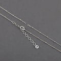 Detail of silver chain with lobster clasp and clear round charm on dark grey background - Silver Polished Chain