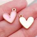 Pink enamel heart charm and gold-plated heart pendant shown on finger for size reference - Pink Heart (14985)