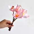 Hand-held pink gradient 3D printed artificial orchid bouquet with yellow center - Pink