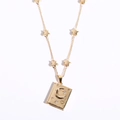 Golden soulmate pendant necklace with crescent moon and star relief on white background - Gold Book Locket / Gold