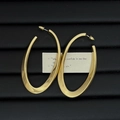 Detailweergave van grote gouden ovale oorringen op een zwart gestructureerd dienblad - Goud (Zilveren oorsteker)