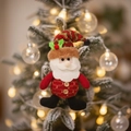 Hanging plush Santa Claus ornament with striped knit hat on a lighted Christmas tree - Santa Claus