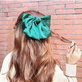 Elegant green satin oversized bow hair clip for women styled on long wavy hair - Spring Clips / Dark Green