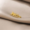 Detail of a golden leaf branch non-pierced nose clip with micro-set zircons on fabric - Leaf Branch (E4751-3)