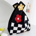 Close-up of black knitted bucket bag with floral patterns and checkerboard base detail - Black Cookie Flower