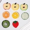Dettaglio di fette di frutta in resina colorata con limone, arancia e fragola per capelli - Misto