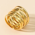 Gepolijste gouden meerlaagse spiraalring met minimalistisch ontwerp op beige achtergrond - Goud
