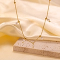 Gold titanium necklace with rice pearls on a stone display over beige satin fabric - [H323] 5 Rice Pearls Gold
