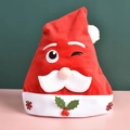 Red plush Santa hat with embroidered snowflakes and a 3D cartoon face for Christmas - Child Winking Santa Hat
