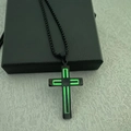 Dettaglio della croce in acciaio nero con striscia verde luminosa su confezione regalo - Luminoso / Nero