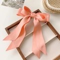 Detailopname van een roze grote strik haarklem met linten op een houten dienblad - Strik veerclip / Roze