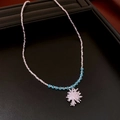 Sky blue crystal bead necklace with silver floral pendant on a black leather cushion - Silver Blue Snowflake Burst Pendant Necklace