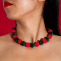 Primer plano detallado del collar de pompones rojos y verdes en modelo para estilo navideño - Rojo y Verde Navidad