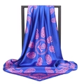 Close-up of blue satin square scarf featuring pink paisley patterns draped on a black frame - 90*90cm / Purple
