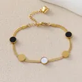 Detail of golden snake chain bracelet featuring black and white circular charms and heart charm - Black White Circle Snake Chain Style (JY142-05)