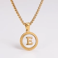 Macro shot of gold stainless steel necklace featuring a round white shell pendant with letter E - Letter E
