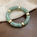 Close-up of iridescent acrylic bead bracelet with gold metal accents and elastic cord - Green (Marble Texture)
