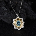 Macro shot of oval blue gemstone pendant with golden honeycomb frame and white zircons - Natural Topaz