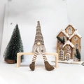 Kerstkabouter met bruin gestreepte gebreide muts en lange benen op houten bankje - Bruin