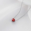 Collana chic in argento con ciondolo a cuore rosso su sfondo di morbido tessuto bianco - Colore Acciaio + Zircone Rosso