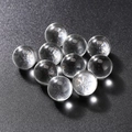 Polished transparent cat eye crystal glass spheres on a black textured background - Clear White