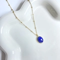 Detail van een 14K vergulde kralenketting met een ovale blauwe edelsteen hanger - Lapislazuli