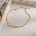 Detailed shot of a gold beaded necklace with adjustable extension chain on beige tray - Gold Metal Round Bead Bracelet