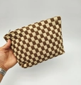 Detail showing hand holding large checkered knit storage bag with brown and beige patterns - Brown Plaid