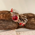 Detail van roségouden armbandhorloge met rode kristallen wijzerplaat op natuursteen - Rood