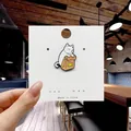 Cute enamel pin featuring a white kitten hiding in a brown bag with yellow fish - 121*White Cat with Fish Bag