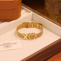 Détail du bracelet en maille dorée avec breloques cœur évidé et X et fermoir montre - Lettre X