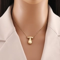 Primo piano della collana con ciondolo in acciaio inossidabile placcato oro 18K su modella - Lettera T