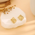 Golden square stud earrings with textured wavy metal finish on a stone display - E6204-33-Wavy Square