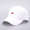 Primer plano del bordado de corazón rojo en la parte frontal de una gorra blanca - Ajustable / Corazón Bordado Blanco