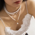 Detail of layered white baroque pearl necklace with a gold T-bar clasp and heart pendant - Gold Baroque Necklace Set 01
