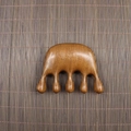 Macro detail of natural sandalwood massage comb with five polished rounded points - Golden Sandalwood Fat Hand Shape (8.3*6.2*2cm)