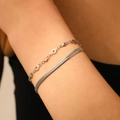 Detail of silver double-layer bracelet with heart charms and flat snake chain on wrist - Steel Star Ring Double Layer Blade Bracelet (T205)