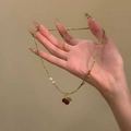 Détail du collier de perles vertes avec un pendentif cerise rouge et des perles - Vert-Rouge-Cerise