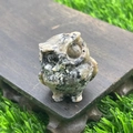 Hand-carved 3.5cm spotted grey stone owl figurine displayed on a dark wooden base - Roadside Stone