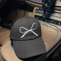 Close-up of high-quality white bow embroidery on a black twill cotton baseball cap - Black