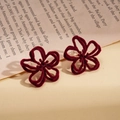 Macro shot of burgundy flocked flower earrings with velvet texture on vintage paper - Wine Red Flocked Style