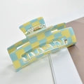Detail of yellow and light blue checkered hair claw clip with a glossy finish on a book - Yellow/Blue Plaid Rectangle
