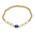 Golden beaded bracelet featuring white pearls and a blue Turkish Evil Eye charm - Evil Eye Pearl Gold Bead Style (BE827GD00)