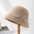 Detail of camel sherpa bucket hat with blue polka dot bow and textured fleece material - Khaki