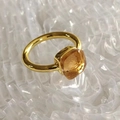 Close-up of golden stainless steel ring with a faceted yellow square cubic zirconia stone - Gold Base: Jul-Champagne